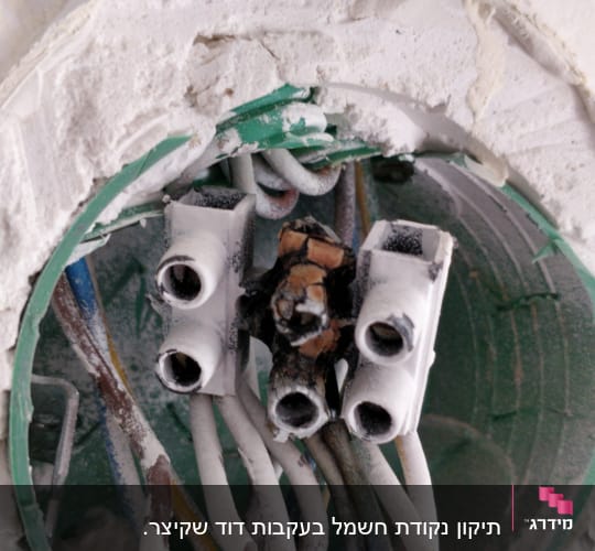 חוטי חשמל מחוברים לקופסת חיבורים בקיר